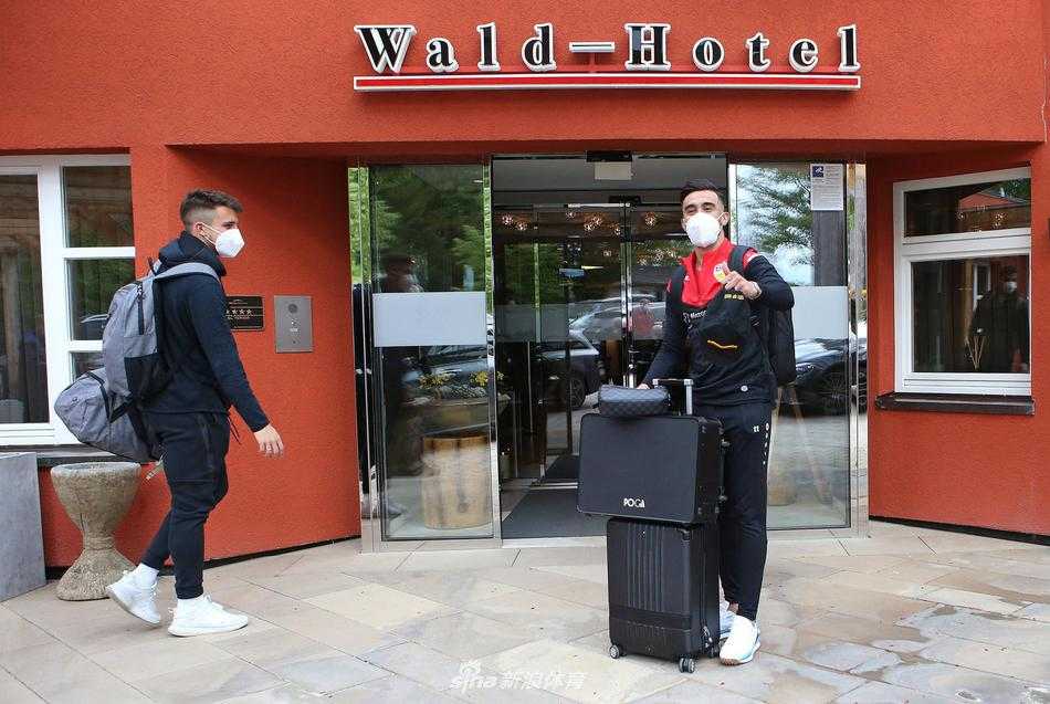 主教练身着一袭黑衣，手提公务包神情严肃地走向酒店，他的每一个细微表情都透露出对这场关键对决的缜密思考