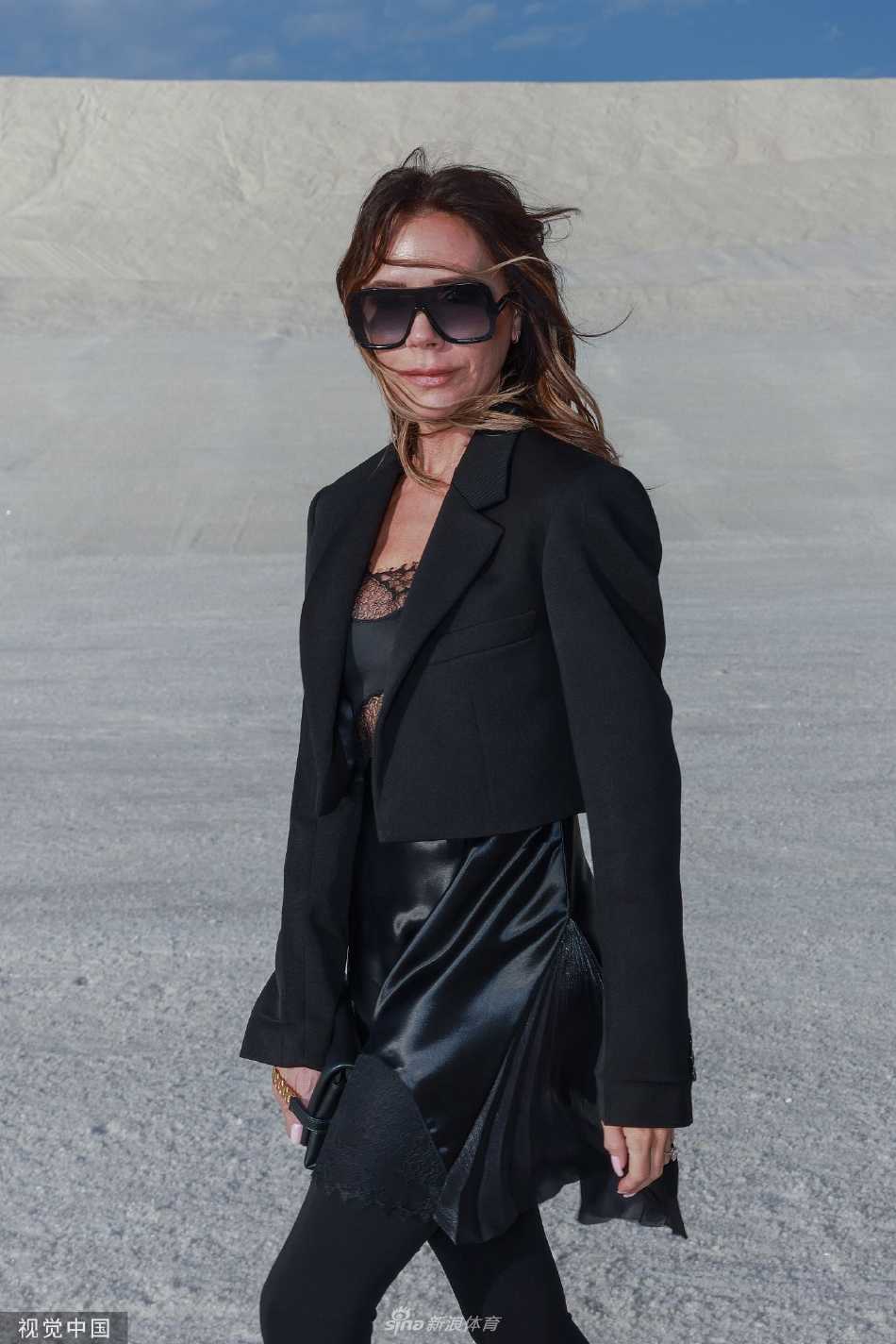 维多利亚·贝克汉姆一袭全黑透视装立于纯白盐山之巅，飒爽身姿与身后苍茫奇景形成极具张力的视觉冲击。