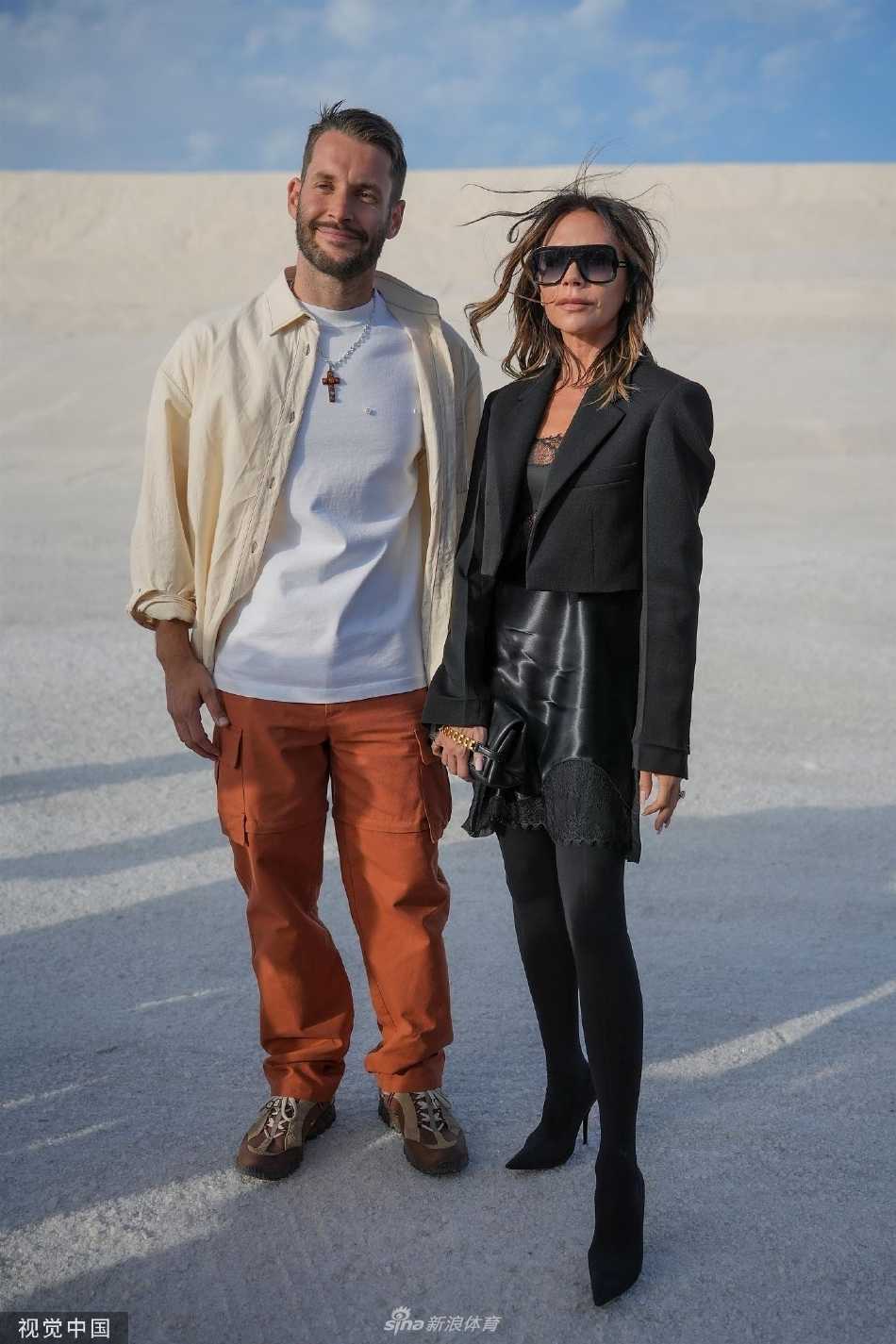 贝嫂侧身回眸，黑色透视装细节尽显，优雅轮廓与远方盐田天际线融为一体，诠释刚柔并济的时尚态度。