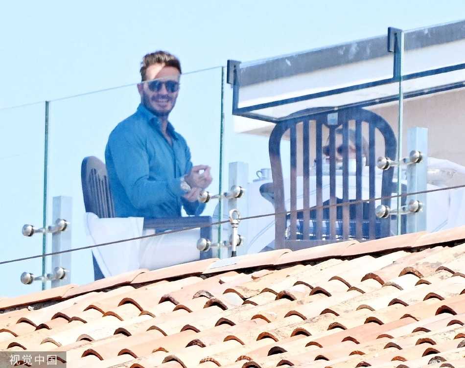 阳光洒在威尼斯运河上，贝克汉姆戴着墨镜帅气掌舵，小七坐在船头惬意欣赏风景，水波荡漾金光点点。