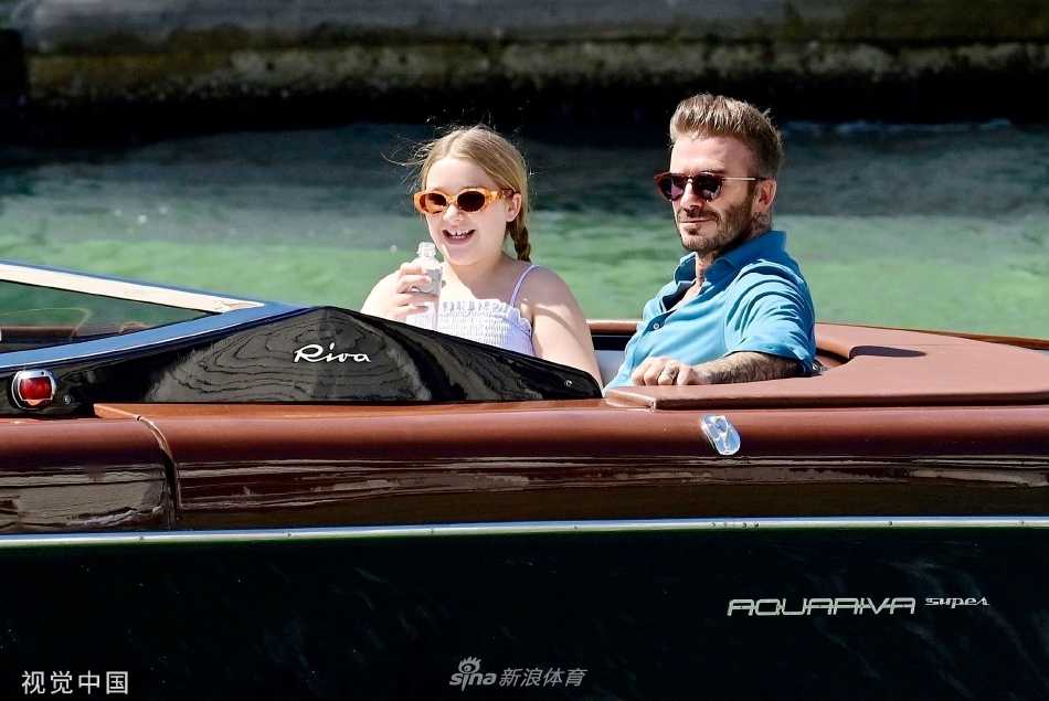 黄昏时分，游船缓缓驶过宁静的河道，贝克汉姆与女儿在柔和光线下低声交谈，背影显得格外温馨宁静。