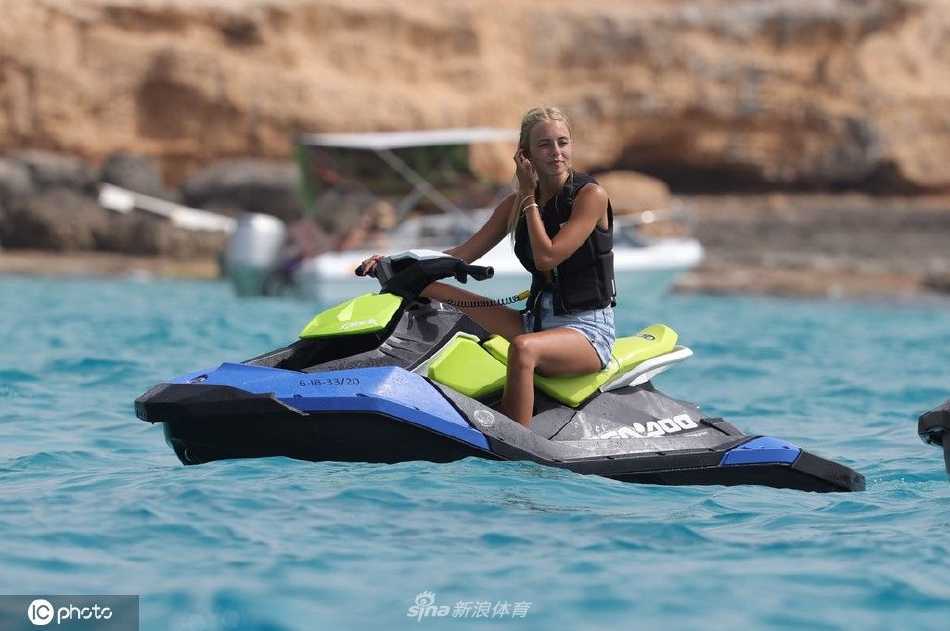 库尔图瓦戴着墨镜，神态放松地驾驶着水上摩托艇，在晶莹剔透的海面上疾驰，溅起欢快的水花。