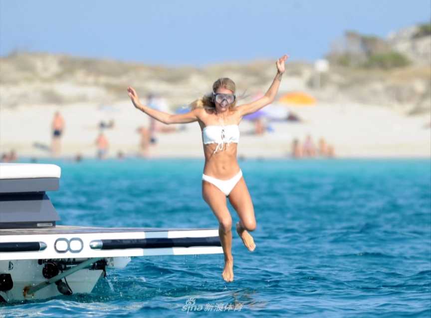 身着白色比基尼的斯嘉丽在游艇上小憩，阳光勾勒出她优美的身体线条，尽显超模的迷人风采。