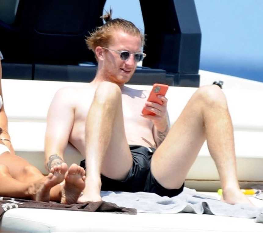 罗伊斯与爱妻斯嘉丽在豪华游艇甲板上并肩而卧，一同享受地中海的温暖日光浴，画面宁静而唯美。