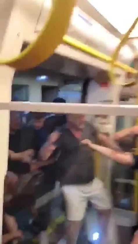 在地铁车厢内，身穿红衣的利物浦球迷与身着天蓝服饰的曼城拥趸扭打在一起，空间狭小却拳脚相向，气氛紧张到了极点。