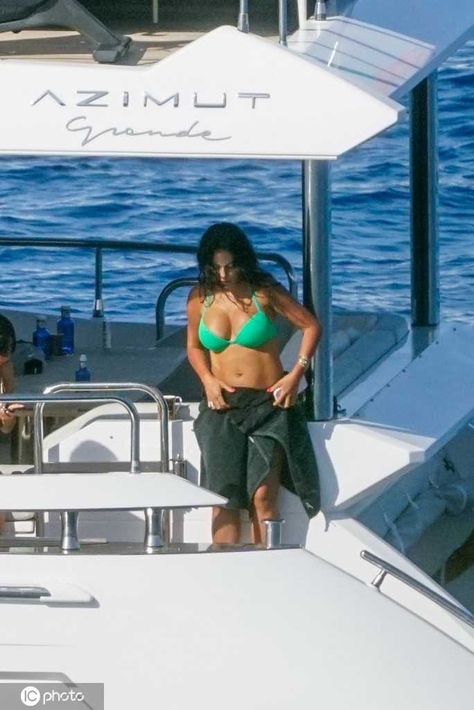 夕阳余晖洒在甲板上，C罗与乔治娜并肩而坐眺望远方，金色的光影为两人勾勒出浪漫的轮廓