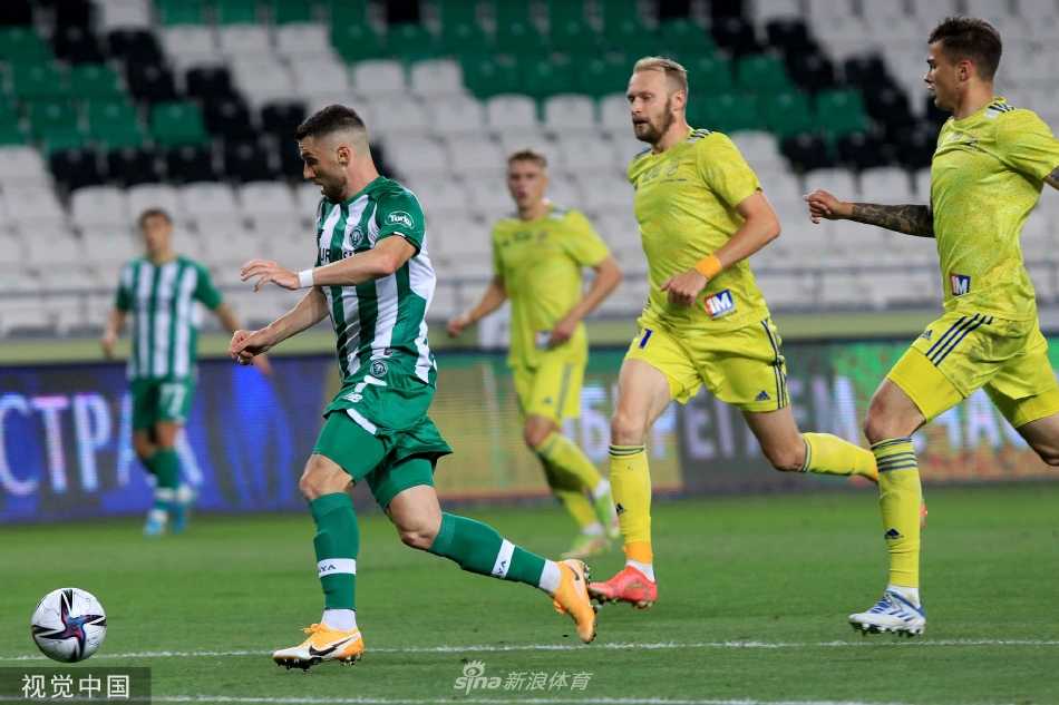 比赛激烈进行中，一名科尼亚球员正欲起脚传中，画面定格瞬间，足球、球员与背景看台构成一幅充满动感的绿茵画卷