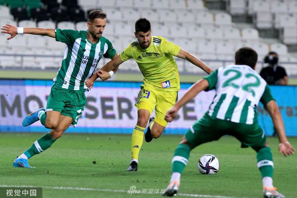 科尼亚队的教练在场边神情专注，手持战术板进行临场指挥，他的运筹帷幄是球队逆境中取胜的关键