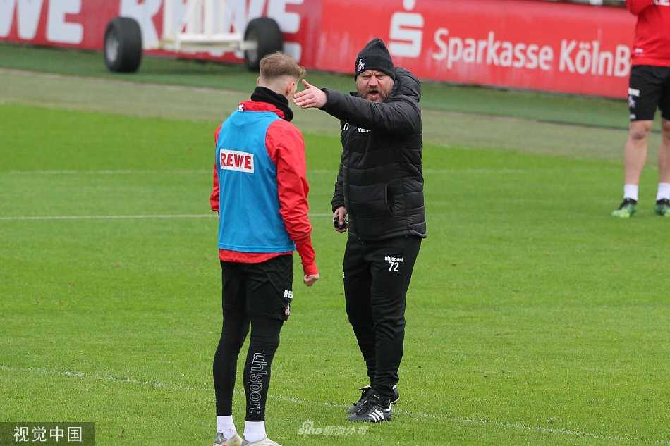 教练组在场边聚精会神地观察训练赛，主教练手持战术笔记，正与助手激烈讨论着某个防守阵型的细节安排。