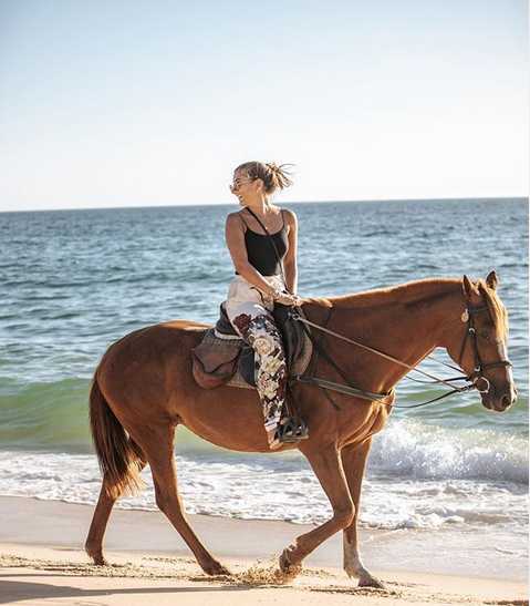 镜头拉近，马蒂尔德在阳光下手扶墨镜回眸一笑，眼神中充满自信与从容，仿佛一幅时尚大片