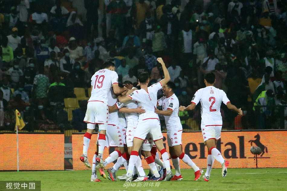 突尼斯队球员在防守中高高跃起，力压尼日利亚进攻队员，将高空球危险解围出禁区。