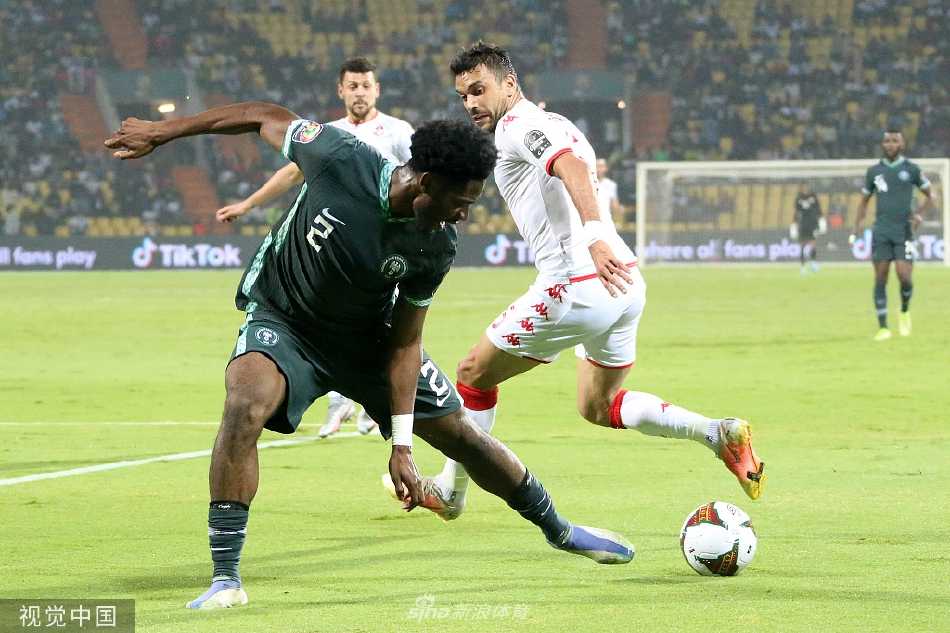 赛后混合采访区，尼日利亚队球星奥斯梅恩背对镜头，他的背影在灯光下显得无比失落与孤独。