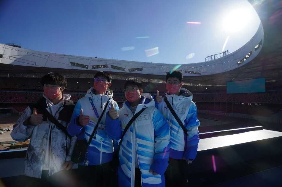 蓝白相间的冬奥主题展区前，两名志愿者手持带有冠军亲笔签名的冰墩墩，眼神中闪烁着回忆的光芒，背景墙上冰雪运动的图案仿佛将他们瞬间拉回到了那个热血沸腾、激情澎湃的冬奥赛季。