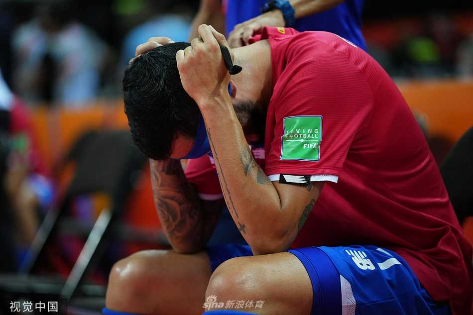 考纳斯的灯光下，一位哥斯达黎加球员独自弯腰低头，双手撑在膝盖上，他的剪影被拉得很长。周围是庆祝的对手和空旷的球场，这份孤独的落寞与背后的喧嚣形成了鲜明而感伤的对比。