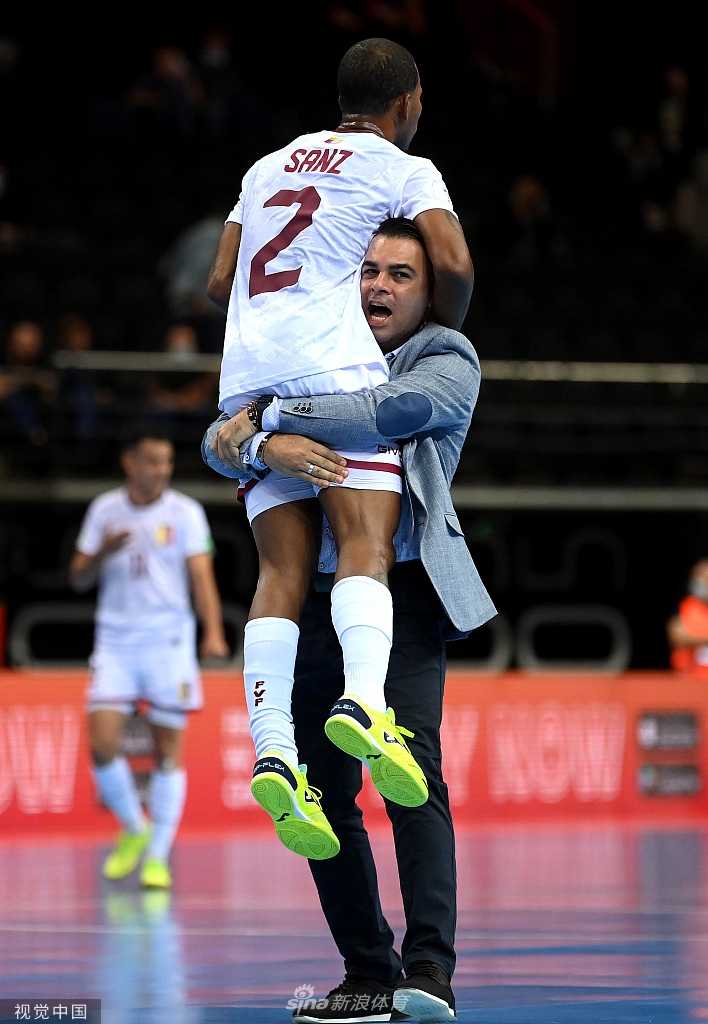 考纳斯球场明亮的灯光下，一颗带有五边形花纹的五人制足球静静地停在白色的边线旁，背景是虚化的绿色球场与球员的倒影，仿佛在诉说着刚才发生在这里的每一次传递与射门。