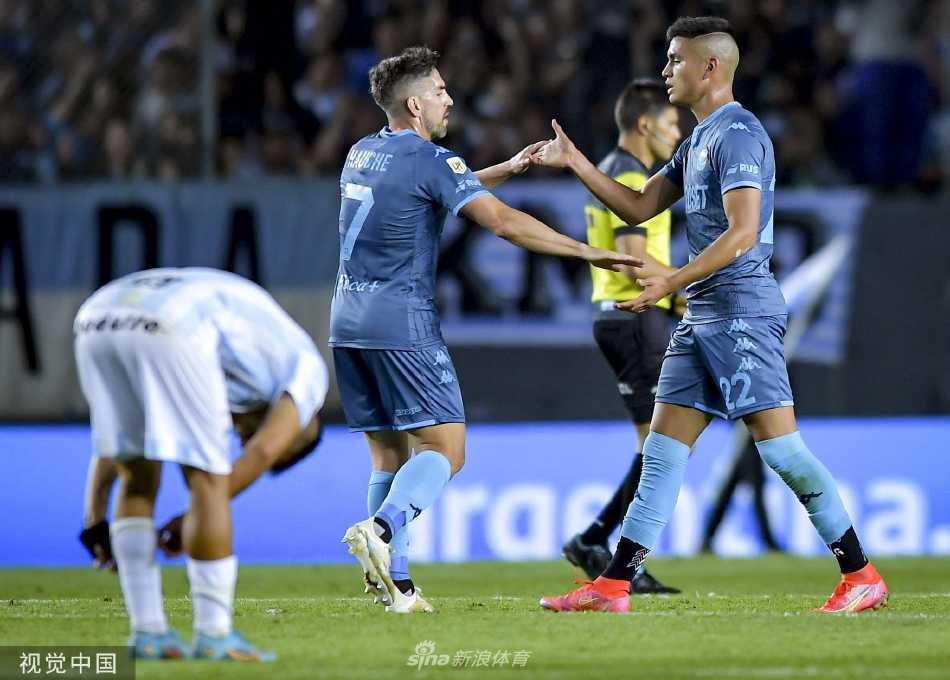 比赛过程中双方球员在中场区域展开激烈拼抢，一名球员正试图用身体护住脚下的足球