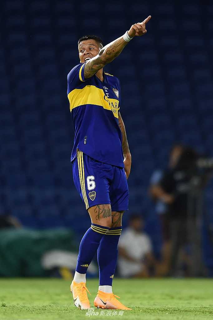 河床队球员在边路突破，面对博卡青年的贴身防守，眼神中透露出对胜利的无限渴望