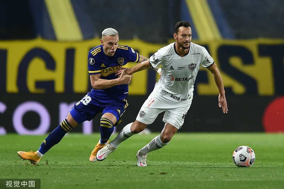 米内罗竞技球员在场上奋力拼抢，他身体前倾，与博卡青年防守球员发生激烈身体接触，脚下的皮球成为争夺的焦点