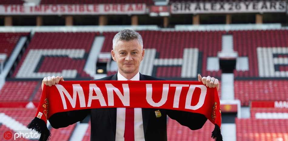 老特拉福德球场看台上，曼联球迷们高举写有“奥莱”的围巾和旗帜，欢迎他们的传奇正式归来