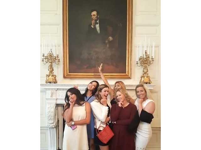 队员们在白宫国宴厅举杯共饮，香槟杯折射出水晶吊灯的璀璨光芒，庆祝的气氛弥漫全场