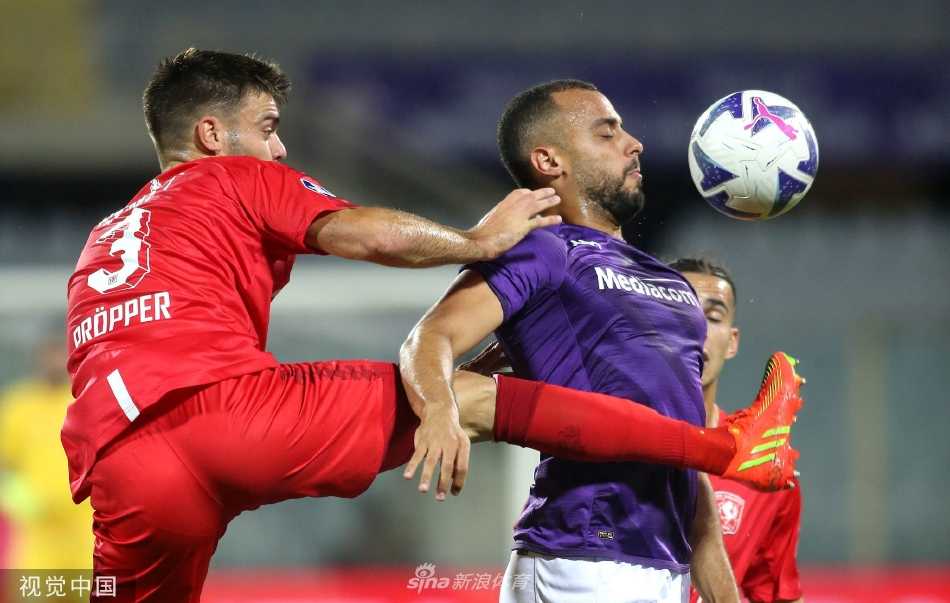 特温特球员庆祝进球，他们紧紧拥抱在一起，脸上写满激动与释放，背景是略显失望的紫色身影。