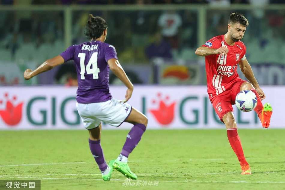 双方球员在比赛中激烈争抢头球，在聚光灯下同时跃起，身影交错，构成一幅充满力量与动感的竞技剪影。