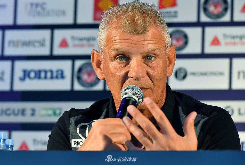 帕特里斯·加拉德在发布会上侧身微笑，与台下的俱乐部工作人员进行眼神交流，传递着团队协作、共渡难关的积极信号。