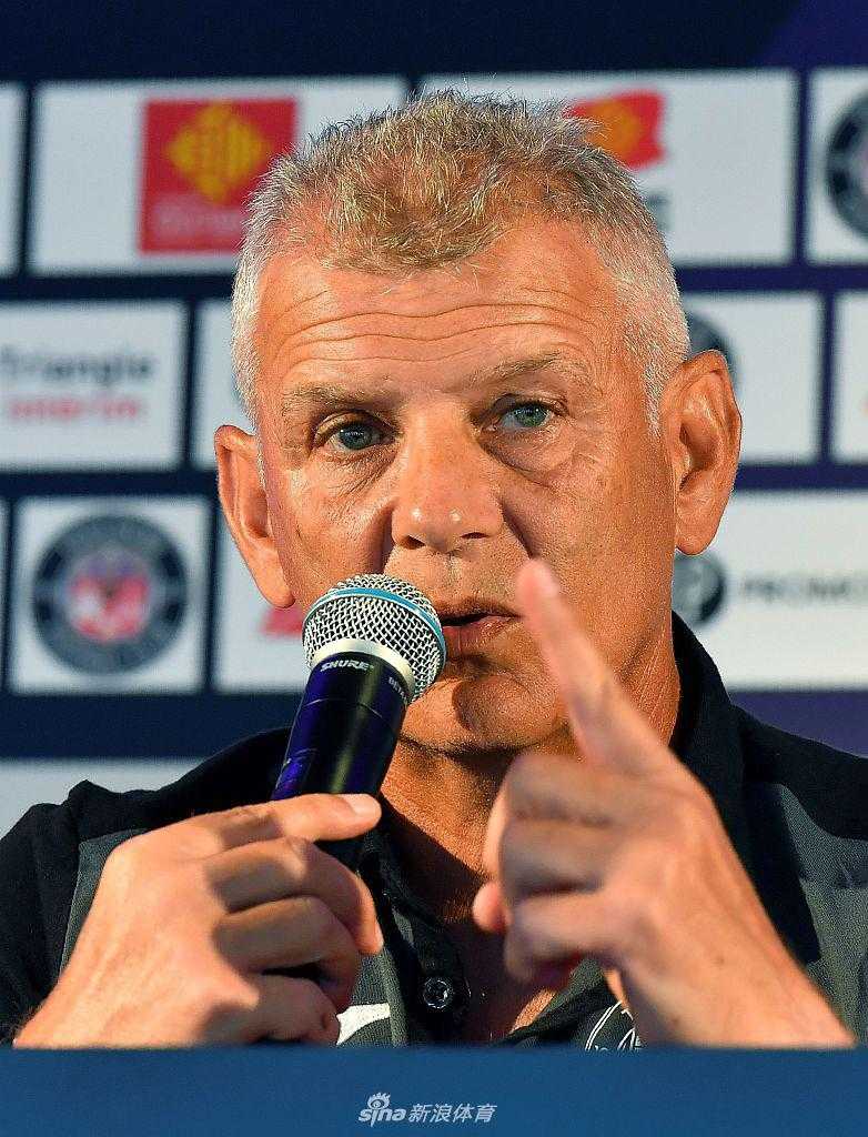 帕特里斯·加拉德手持图卢兹紫色围巾，面对台下的镜头和记者，他的姿态从容不迫，展现出一位老帅运筹帷幄的自信。