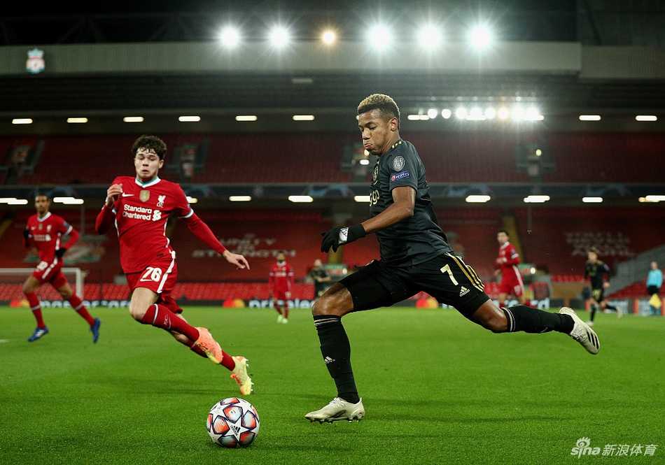 萨拉赫在边路面对阿贾克斯球员的贴身紧逼，眼神专注于皮球，埃及法老与对手展开激烈的身体对抗。