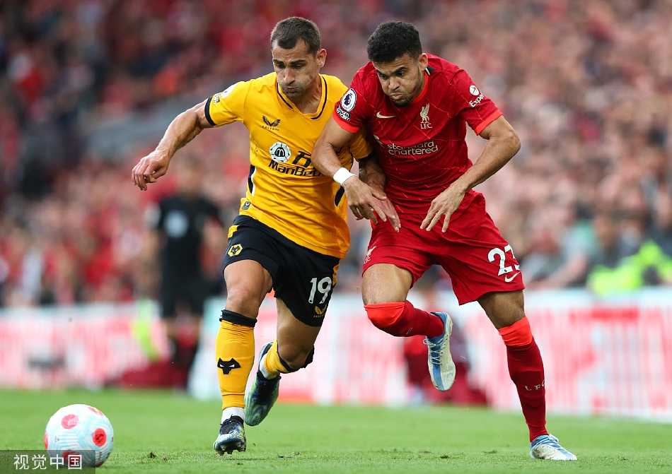 进球功臣罗伯逊与队友菲尔米诺在角旗区紧紧相拥庆祝锁定胜局的进球，身旁是沸腾的红色海洋。