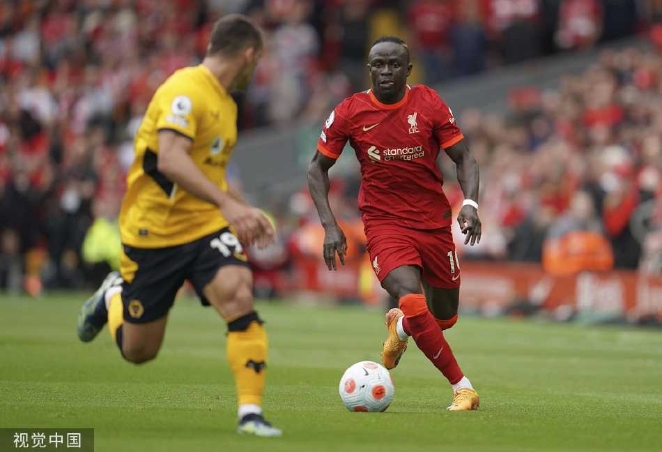 看台上数万名利物浦球迷高举围巾，在终场哨响后依然用歌声支持球队，画面中交织着失落与不变的忠诚。