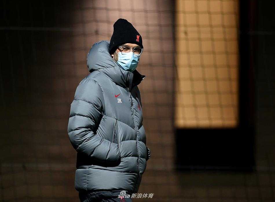 萨拉赫在训练中弯下腰系紧鞋带，背后的广告牌上印着利物浦队徽，仿佛战神在擦拭他的战靴。