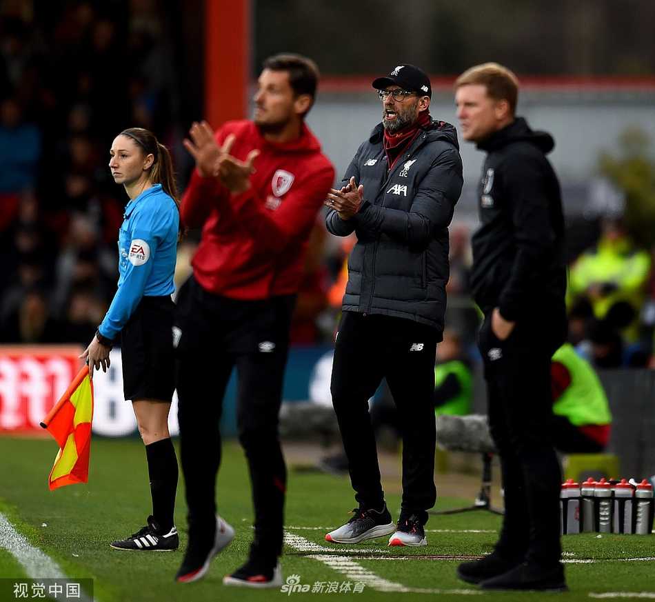 萨拉赫进球后跪地滑行庆祝，双手指天，脸上洋溢着自信与喜悦，身后的球迷在看台上疯狂欢呼