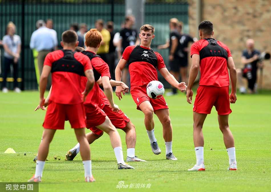 亨德森在训练中奋力呼喊，手臂高高扬起，指挥着队友跑位，队长袖标在阳光下格外醒目。