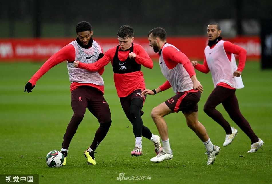 利物浦球员在训练中专注地进行短传配合练习，绿茵场在冬日阳光下显得格外醒目