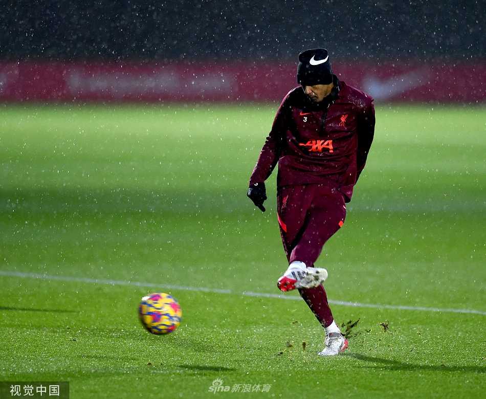 训练结束后，几名利物浦球员边走边交流，气氛轻松，背景是暮色下的训练场设施，画面宁静而富有生活气息。