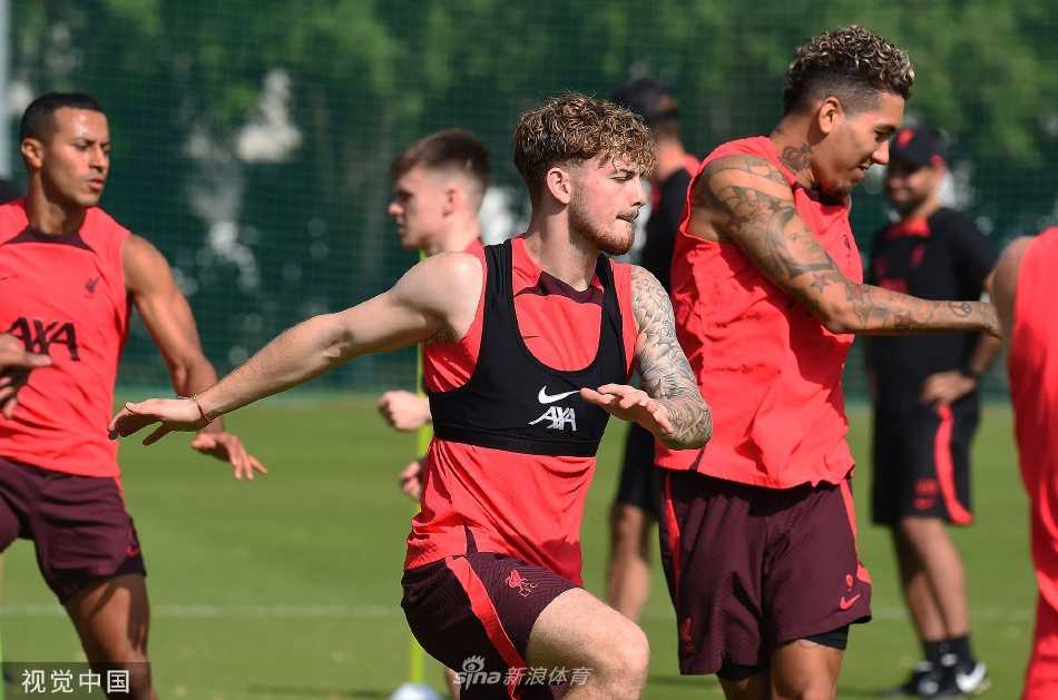 夕阳下的合练：全队球员在黄昏时分进行整体阵型移动训练，身影整齐划一，在金色余晖的映照下构成一幅充满力量与美感的足球画卷。