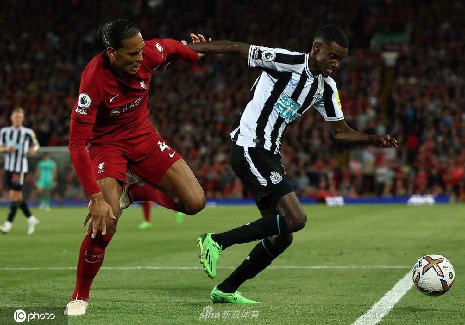 看台上一位小球迷身披利物浦围巾，眼神中充满了对胜利的渴望与自豪