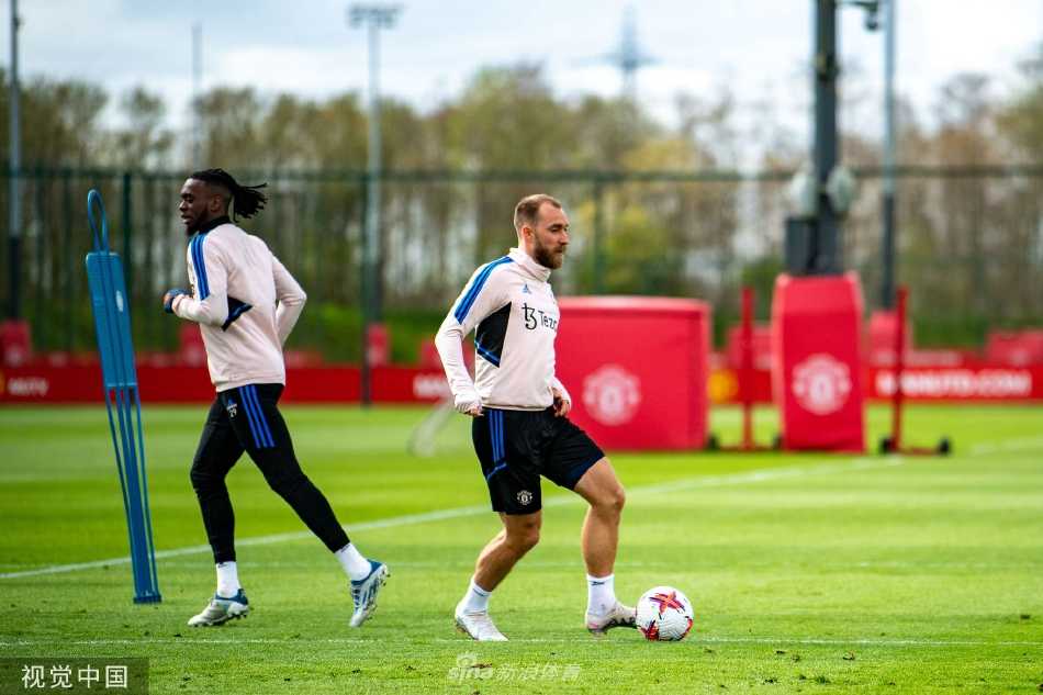 曼联球员围成一圈进行赛前战术部署会议，众人神情专注聆听，中间球员手持足球，凸显团队严谨的赛前准备与凝聚力。