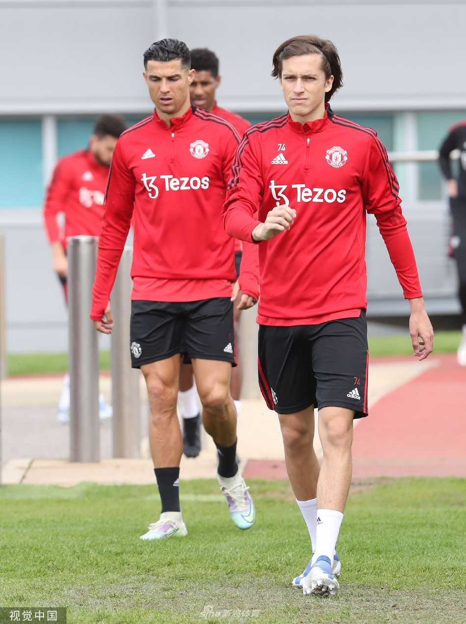 曼联球员在绿茵场上全神贯注进行战术演练，主教练在一旁细致指导，阳光映照出他们为赛季最后一战拼搏的决心。