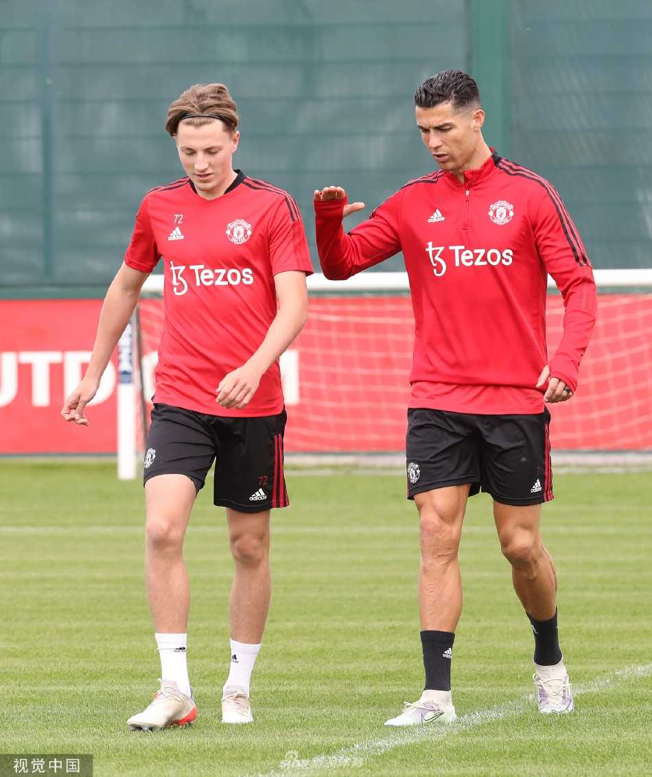 球员在训练间隙与教练团队认真交流战术板，彼此眼神专注，体现着场上场下紧密的团队协作与沟通。