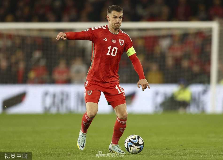 威尔士与拉脱维亚球员在中场激烈拼抢，双方身体对抗激烈，球鞋草屑飞扬，争夺寸土不让。