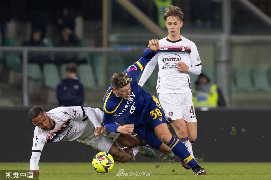 维罗纳队长杜达在中场带球推进，面对两名防守球员的包夹，他神态自若，正准备送出关键传球。