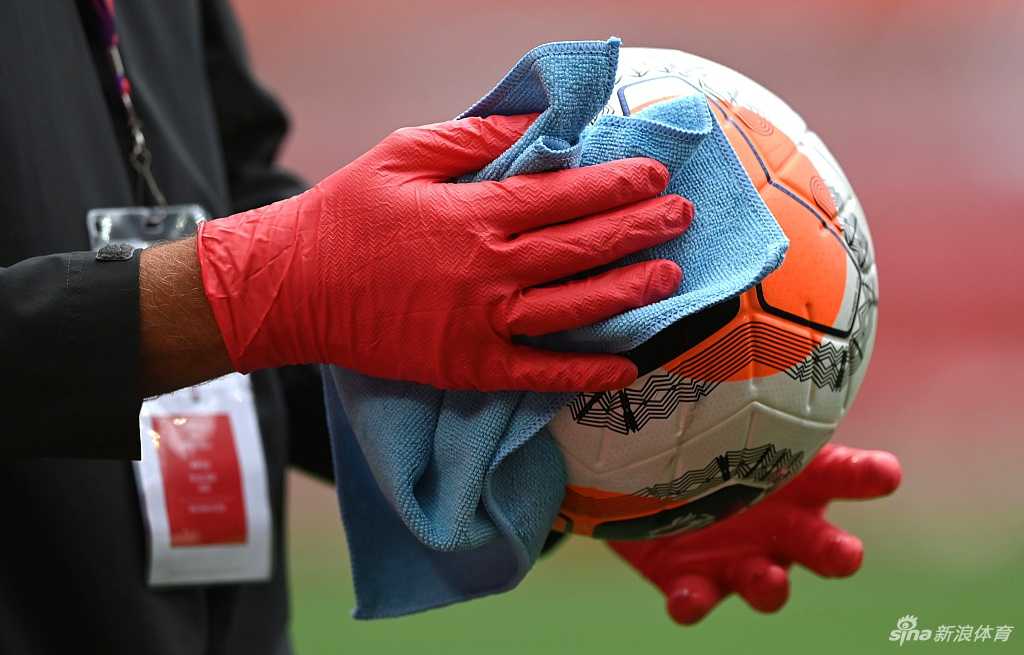 身穿防护装备的医务人员正隔着车窗，为英超球员进行新冠病毒检测采样，这一幕成为疫情期间联赛重启的特殊日常写照。