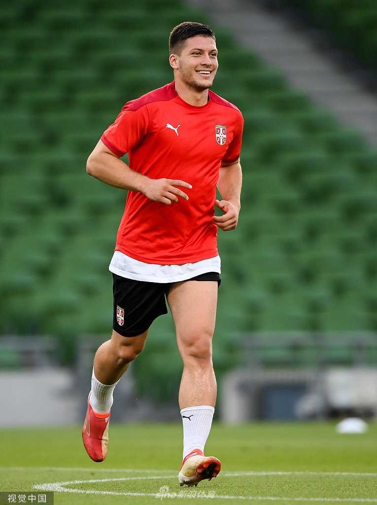 在体能教练的指导下，一名塞尔维亚球员正在进行高强度的敏捷梯训练，他的脚步快速而精准，扬起的草屑和专注的神情证明了他们对这场关键战役的重视程度。