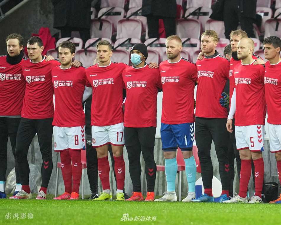 赛前仪式上，丹麦队的球员们并肩而立，他们身着的红色T恤如同一片燃烧的正义之火。在这片绿茵舞台上，足球暂时退居其次，球员们化身为无声的代言人，用团结的姿态为万里之外、默默无闻的劳工群体争取关注与尊严。