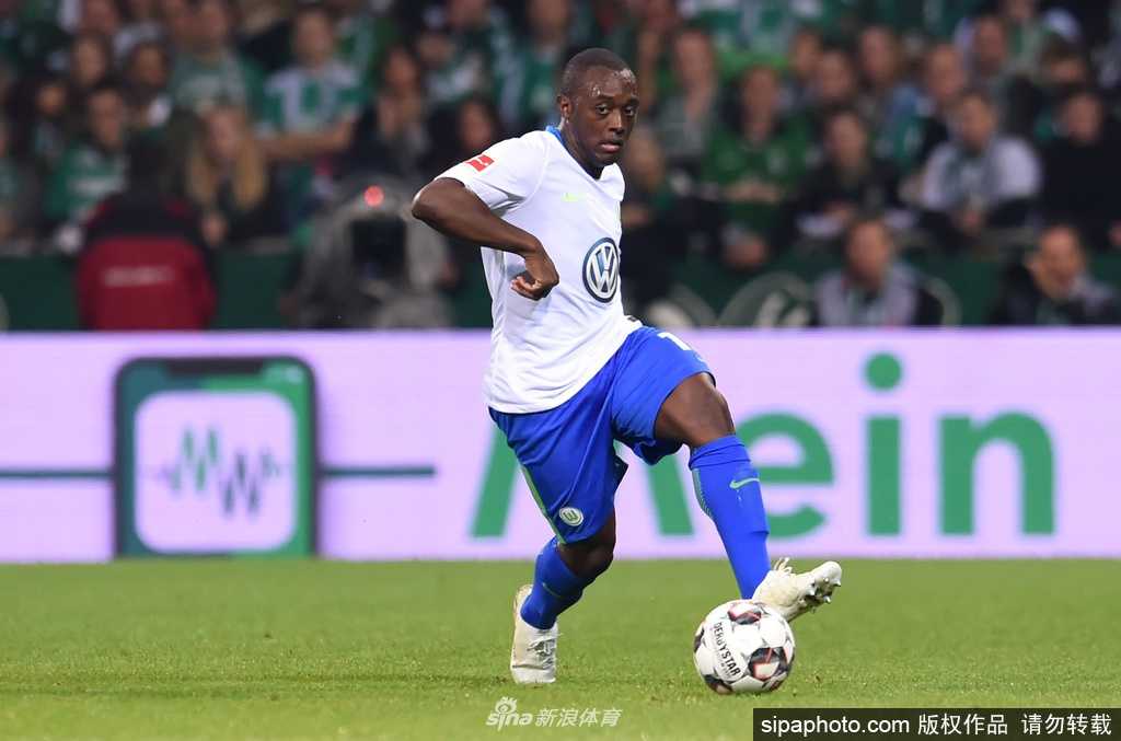 沃尔夫斯堡队长袖标静静摆放在更衣室的座椅上，背后是印有球员号码的整齐球衣，更衣柜门上贴着激励士气的队徽贴纸，整个空间充满临战前又突然凝固的寂静