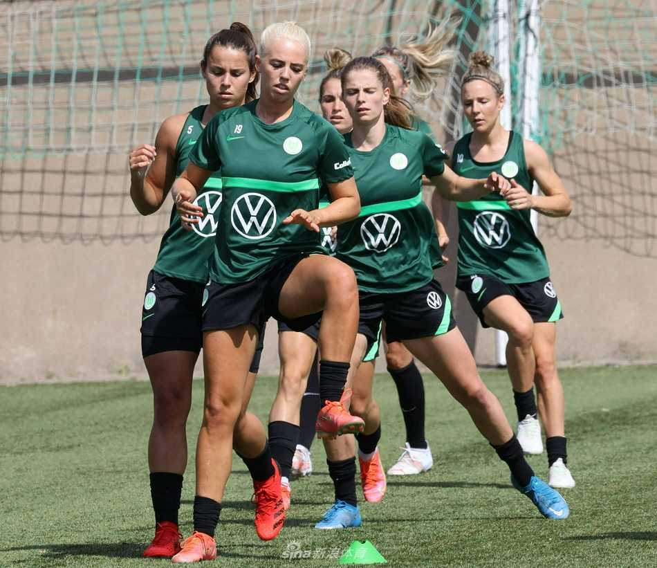 阳光洒在绿茵场上，一位沃尔夫斯堡女足球员正神情专注地进行抢圈训练，她敏捷的身影仿佛一道闪电，随时准备撕裂对手的防线。