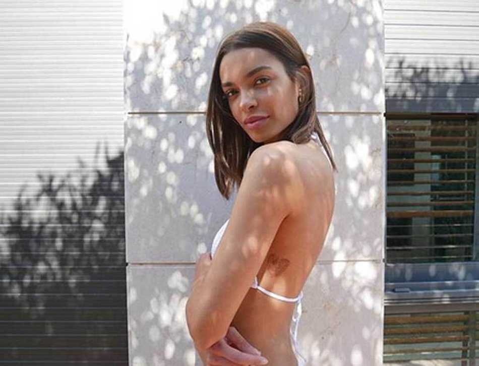 乔安娜·桑兹在摄影棚内，身穿剪裁得体的时尚外套，眼神自信地望向前方，整个画面充满了高级时尚感与强大的气场。